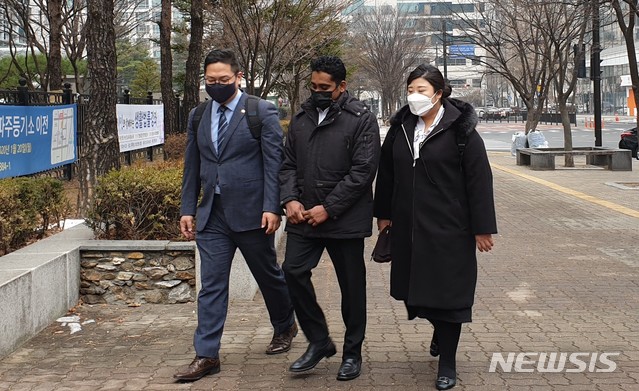 [고양=뉴시스]송주현기자 = 23일 경기 고양시의 '저유소 화재' 피고인인 외국인 근로자 디무두씨가 변호인들과 함께 의정부지법 고양지원으로 들어가고 있다. 2020.12.23. atia@newsis.com