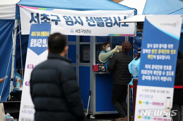 [서울=뉴시스]김선웅 기자 = 1092명의 신규 코로나19 확진자가 발생한 23일 서울 서초구 고속버스터미널 앞에 설치된 서초구 임시선별검사소에서 의료진이 검체를 채취하고 있다. 2020.12.23. mangusta@newsis.com