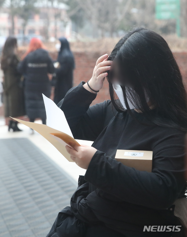 [서울=뉴시스] 사진공동취재단 = 수험생이 23일 오전 서울 중구 이화여고에서 2021학년도 대학수학능력시험 성적표를 확인하고 있다. 2020.12.23. photo@newsis.com