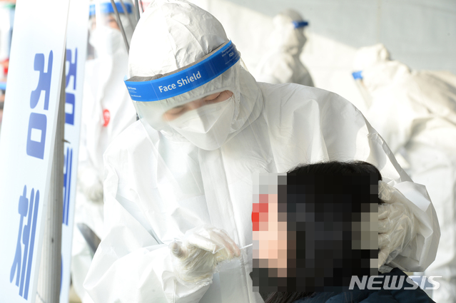 [울산=뉴시스] 배병수 기자 = 신종 코로나바이러스 감염증(코로나19)이 전국적으로 확산하고 있는 가운데 23일 오전 울산 울주군 범서생활체육공원에 마련된 선별진료소에서 의료진이 검체 채취를 하고 있다. 2020.12.23. bbs@newsis.com.