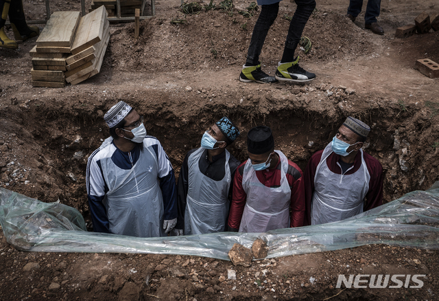 [요하네스버그=AP/뉴시스] 지난달 26일(현지시간) 남아프리카공화국(남아공) 요하네스버그의 한 공동묘지에서 직원들이 시신을 묻기 위해 준비하는 모습. 코로나19 변이 바이러스가 확산되기 시작한 남아공은 12월 누적 확진자 수가 100만명을 넘어섰다. 2020.12.29.