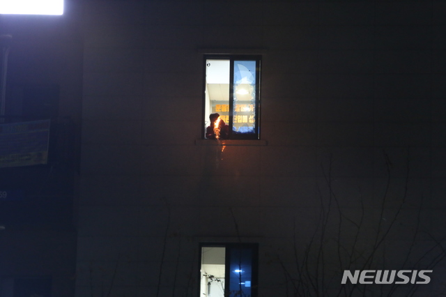 [청주=뉴시스] 조성현 기자 = 28일 오후 11시30분께 충북 청주시 청원구 율량동 한 4층 건물에서 불을 지르겠다고 경찰과 대치한 30대 남성이 12시간 만에 검거됐다. 사진은 30대 남성이 불을 지르겠다고 경찰 등을 위협하는 모습. 2020.12.28. jsh0128@newsis.com