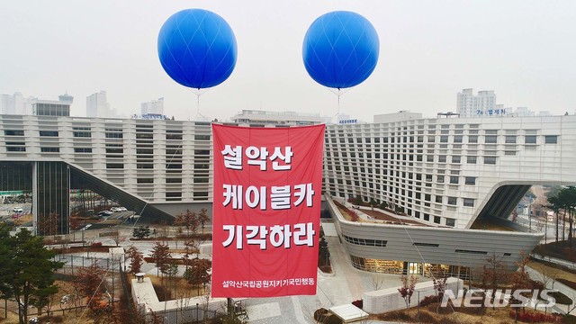 [서울=뉴시스]설악산국립공원지키기국민행동이 29일 세종시 정부세종청사에서 설악산케이블카 행정심판 기각 촉구 고공피켓팅을 하고 있다. 중앙행정심판위원회는 이날 세종청사에서 설악산오색케이블카 부동의 건에 대한 행정심판을 심리를 시작한다. 2020.12.29. (사진=설악산국립공원지키기국민행동 제공) photo@newsis.com