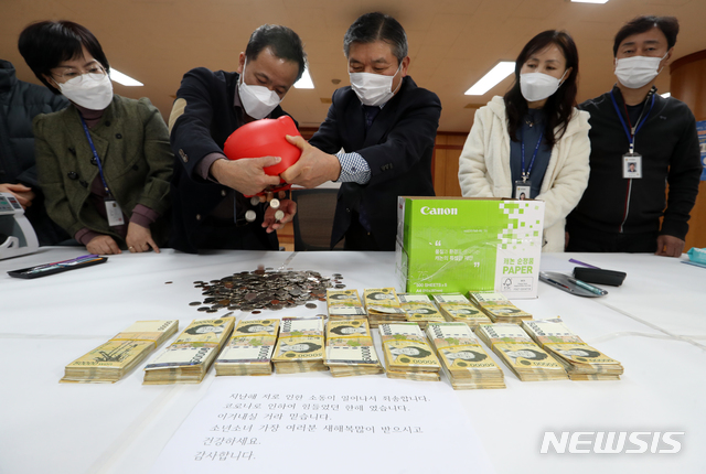 [전주=뉴시스] 김얼 기자 = 29일 전북 전주시 노송동주민센터에서 직원들이 '얼굴 없는 천사'가 놓고 간 성금을 세고 있다. '얼굴 없는 천사'는 7012만 8980원의 성금과 함께 '지난해 저로 인한 소동이 일어나서 죄송합니다. 코로나로 인하여 힘들었던 한해였습니다. 이겨내실 거라 믿습니다. 소년소녀 가장 여러분 새해 복 많이 받으시고 건강하세요. 감사합니다.'라는 글을 함께 보내왔다. 2020.12.29. (사진=전북사진기자단) pmkeul@newsis.com