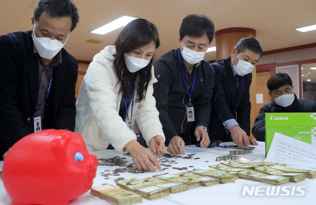 [전주=뉴시스] 김얼 기자 = 29일 전북 전주시 노송동주민센터에서 직원들이 '얼굴 없는 천사'가 놓고 간 성금을 세고 있다. '얼굴 없는 천사'는 7012만 8980원의 성금과 함께 '지난해 저로 인한 소동이 일어나서 죄송합니다. 코로나로 인하여 힘들었던 한해였습니다. 이겨내실 거라 믿습니다. 소년소녀 가장 여러분 새해 복 많이 받으시고 건강하세요. 감사합니다.'라는 글을 함께 보내왔다. 2020.12.29. (사진=전북사진기자단) pmkeul@newsis.com