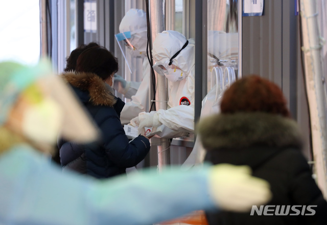 [서울=뉴시스] 고승민 기자 = 한해의 마지막 때를 일컫는 '세밑' 한파가 시작된 30일 서울역 중구임시선별진료소 컨테이너에서 의료진들이 검사 업무를 하고 있다. 2020.12.30. kkssmm99@newsis.com 