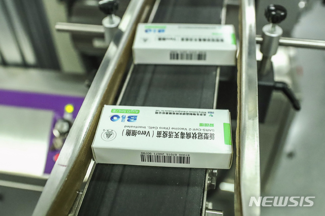 [베이징=AP/뉴시스] 작년 12월 25일 중국 시노팜(중국의약집단) 베이징 연구소 생산라인에서 코로나19 백신이 생산되는 모습. 