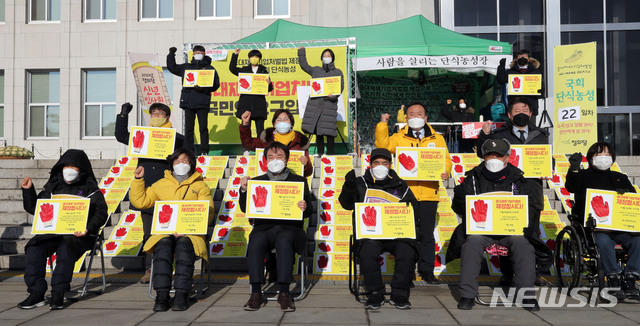 [서울=뉴시스] 전진환 기자 =  1일 오전 서울 여의도 국회 본관 앞 단식농성장에서 열린 정의당 신년인사회에서 김종철 대표 등 참석자들이 중대재해기업처벌법 제정 촉구 구호를 외치고 있다. (공동취재사진) 2021.01.01. photo@newsis.com