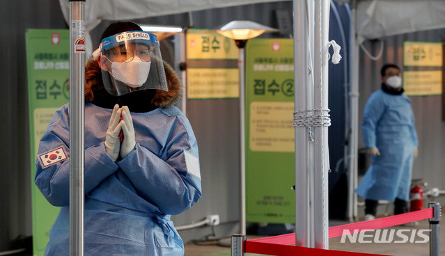 [서울=뉴시스] 김병문 기자 = 새해 첫날인 1일 오후 서울 중구 서울광장 임시선별진료소에서 육군 현장지원팀원이 핫팩으로 손을 녹이고 있다. 2021.01.01. dadazon@newsis.com