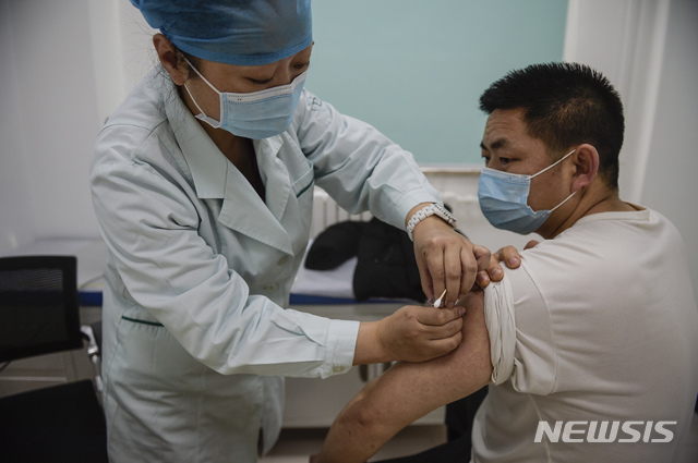 [베이징=AP/뉴시스] 중국 베이징의 지정기관에서 한 남성이 시노팜(중국의약집단)에서 개발한 코로나19 백신을 접종하고 있다. 2020.01.04 