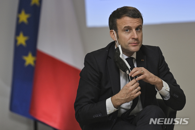 [투르=AP/뉴시스] 지난 5일(현지시간) 프랑스 서부 투르에 위치한 복지 기관에서 에마뉘엘 마크롱 프랑스 대통령이 마스크를 벗고 있다. 2021.01.06.