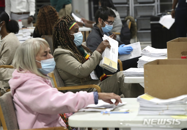 [로렌스빌=AP/뉴시스]조지아 선거관리원들이 5일(현지시간) 로렌스빌 선거관리 건물에서 조지아 연방 상원의원 결선 우편투표 용지를 분류하고 있다. 2021.1.6.