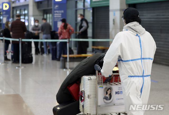 [인천공항=뉴시스]최진석 기자 = 공항으로 입국하는 모든 외국인들의 신종 코로나바이러스 감염증(코로나19) 유전자증폭(PCR) 검사 음성 확인서 제출 의무화를 하루 앞둔 7일 인천국제공항 제1터미널 입국장에서 방역복을 입은 이용객이 이동하고 있다. 2021.01.07. myjs@newsis.com