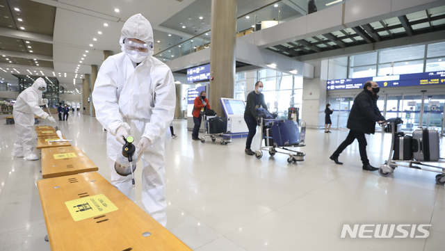 [인천공항=뉴시스]최진석 기자 = 공항으로 입국하는 모든 외국인들의 신종 코로나바이러스 감염증(코로나19) 유전자증폭(PCR) 검사 음성 확인서 제출 의무화를 하루 앞둔 지난달 7일 인천국제공항 제1터미널 입국장에서 방역복을 입고 방역작업을 하는 관계자들 뒤로 유럽발 외국인 입국자들이 이동하고 있다. 2021.01.07. myjs@newsis.com