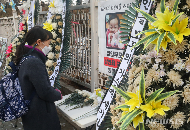[서울=뉴시스]배훈식 기자 = 학대를 받아 숨진 것으로 알려진 정인이 양부모에 대한 재판을 하루 앞둔 지난 12일 오전 서울 양천구 서울남부지검 앞에 마련된 정인이 영정 앞에서 한 시민이 헌화하고 있다. 2021.01.12. dahora83@newsis.com