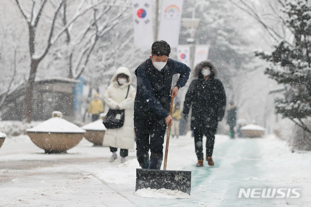 [서울=뉴시스] 박민석 기자 = 서울 지역에 눈이 내린 지난 12일 오후 서울 성동구 성동구청에서 구청 직원들이 구청사 주변 보행로에 대한 제설 작업을 하고 있다. (사진=성동구 제공) 2021.01.12. photo@newsis.com