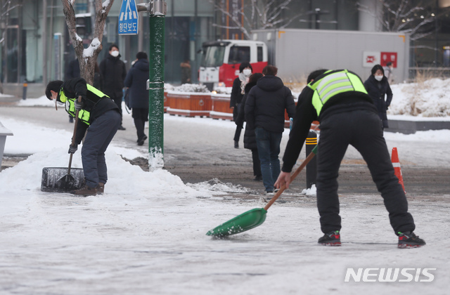 [서울=뉴시스]고승민 기자 = 서울지역에 폭설이 내린 이튿날인 13일 서울 광화문 사거리에서 서울시 관계자들이 제설작업을 하고 있다. 2021.01.13. kkssmm99@newsis.com