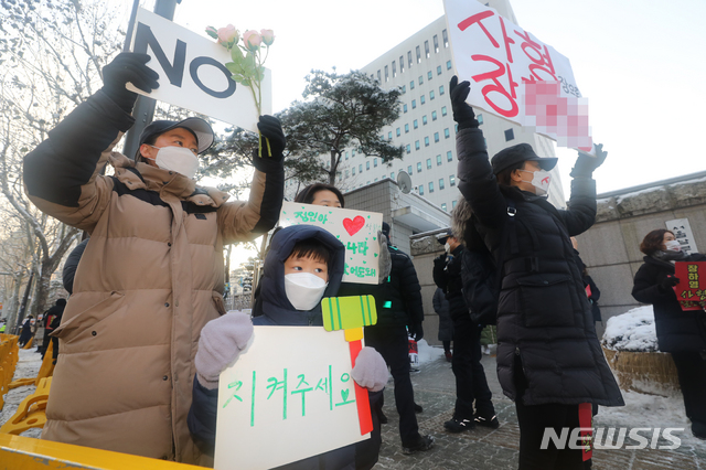 [서울=뉴시스]배훈식 기자 = 학대 받아 숨진 것으로 알려진 정인이 양부모에 대한 첫 재판이 열리는 13일 오전 서울 양천구 서울남부지방검찰청 앞에서 대한아동학대방지협회 회원과 시민들이 피켓 시위를 하고 있다. 2021.01.13. dahora83@newsis.com