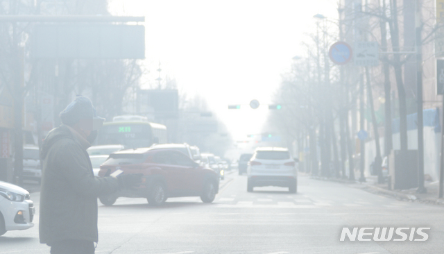 [전주=뉴시스] 김얼 기자 = 전북지역의 미세먼지와 초미세먼지, 황사가 나쁨 수준을 보이는 14일 전북 전주시 덕진구 팔달로를 지나는 시민들 뒤로 도심이 뿌옇게 흐려져 있다. pmkeul@newsis.com