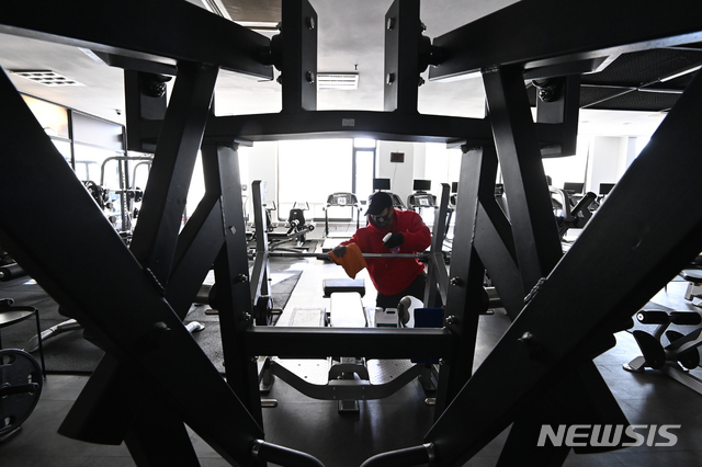 [용인=뉴시스] 김종택기자 = 14일 오후 경기도 용인시 수지구 한 휘트니스센터에서 관계자가 운동기구를 소독하며 영업준비를 하고 있다. 정부는 사회적 거리두기 수도권 2.5단계, 비수도권 2단계 조치 종료를 앞두고 헬스장 등 실내체육시설 집합금지를 완화하되 5인 이상 사적모임 금지 조치는 유지할 가능성이 높다고 밝혔다. 2021.01.14. jtk@newsis.com