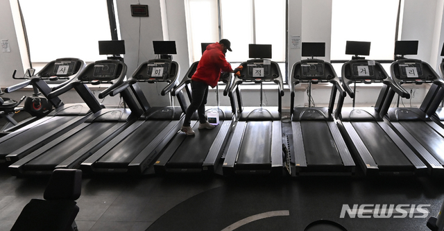 [용인=뉴시스] 김종택 기자 = 지난 14일 오후 경기도 용인시 수지구 한 휘트니스센터에서 관계자가 운동기구를 소독하며 영업준비를 하고 있다. 정부는 사회적 거리두기 수도권 2.5단계, 비수도권 2단계 조치 종료를 앞두고 헬스장 등 실내체육시설 집합금지를 완화하되 5인 이상 사적모임 금지 조치는 유지할 가능성이 높다고 밝혔다. 2021.01.14. jtk@newsis.com