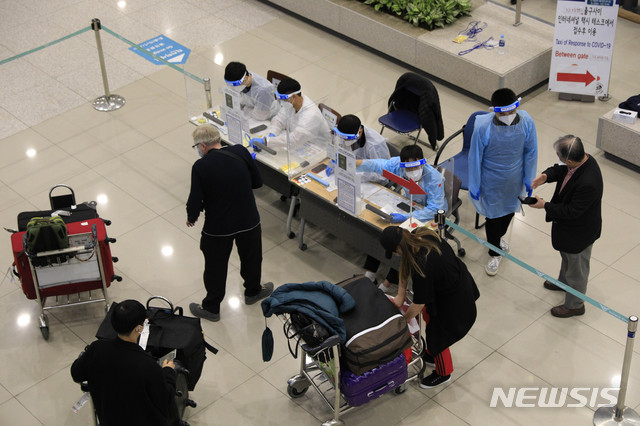 [인천공항=뉴시스]박민석 기자 = 신종 코로나바이러스 감염증(코로나19) 해외 유입 확진자가 28명으로 집계된 14일 오후 인천국제공항 제1터미널 입국장에서 방역 관계자들이 입국 승객들을 안내하고 있다. 2021.01.14. mspark@newsis.com