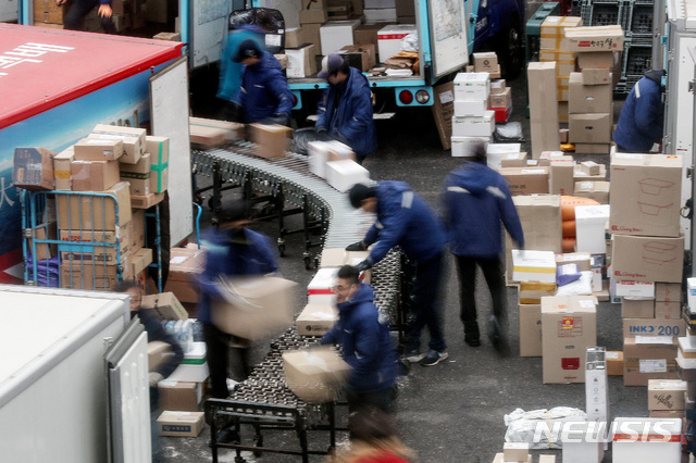 [서울=뉴시스]김병문 기자 = 설 명절을 한 달여 앞둔 15일 오전 서울의 한 택배사 물류센터에서 택배노동자들이 분류 및 상차 작업을 하고 있다. 지난 8일 생활물류서비스산업발전법(생활물류법) 제정안이 국회 본회의를 통과했으나 '분류작업'과 관련한 책임 소재는 명시되지 않았다. 2021.01.15. dadazon@newsis.com