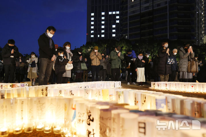 [고베=AP/뉴시스]2021년 1월 17일 일본 고베의 한 기념관에서 한신대지진 희생자를 추도하는 사람들이 등불 앞에서 묵념하고 있다. 2025.01.17. 