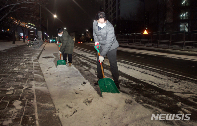 [서울=뉴시스]제설대책 비상근무에 나선 동작구청 직원들이 지난 17일 서울 동작구 흑석동 도로에서 주민들의 안전을 위해 염화칼슘을 뿌리고 제설작업을 하고 있다.(사진=동작구청 제공) 2020.11.17. photo@newsis.com