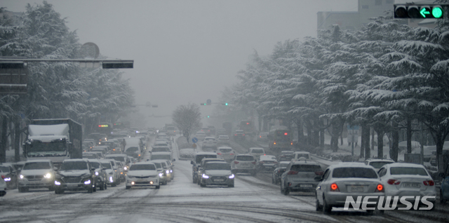 [전주=뉴시스] 김얼 기자 = 전북지역에 대설주의보가 발효된 18일 전주시 덕진구 백제대로에서 출근하는 운전자들이 눈 가득 쌓인 혼잡한 도로를 천천히 달리고 있다. 2021.01.18. pmkeul@newsis.com