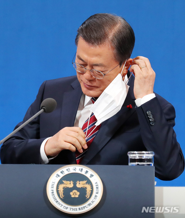 [서울=뉴시스]추상철 기자 =문재인 대통령이 18일 오전 청와대 춘추관에서 온·오프 혼합 방식으로 열린 '2021 신년 기자회견'에 참석해 마스크를 벗고 있다. 2021.01.18. scchoo@newsis.com