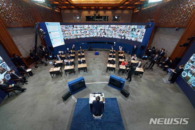 [서울=뉴시스]추상철 기자 =문재인 대통령이 18일 오전 청와대 춘추관에서 온·오프 혼합 방식으로 열린 '2021 신년 기자회견'에 참석해 번호판을 든 취재진을 바라보고 있다. 2021.01.18. scchoo@newsis.com