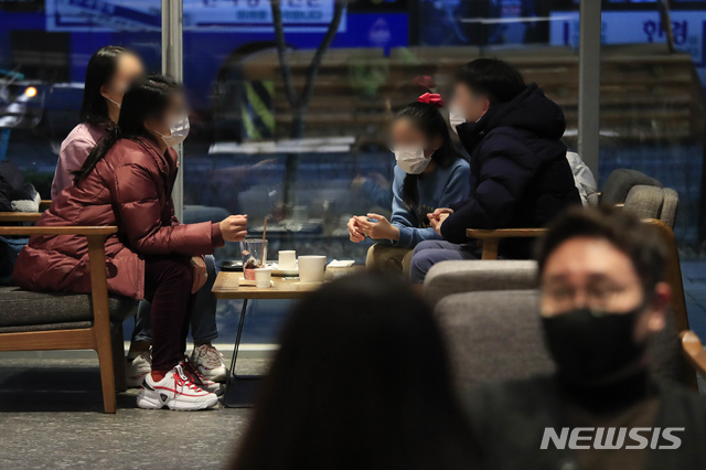 [서울=뉴시스]박민석 기자 = 다중이용시설에 대한 집합금지·운영제한이 완화된 19일 오후 서울 마포구 홍익대학교 인근의 한 프렌차이즈형 카페에서 마스크를 착용한 시민들이 커피를 마시고 있다. 2021.01.19. mspark@newsis.com