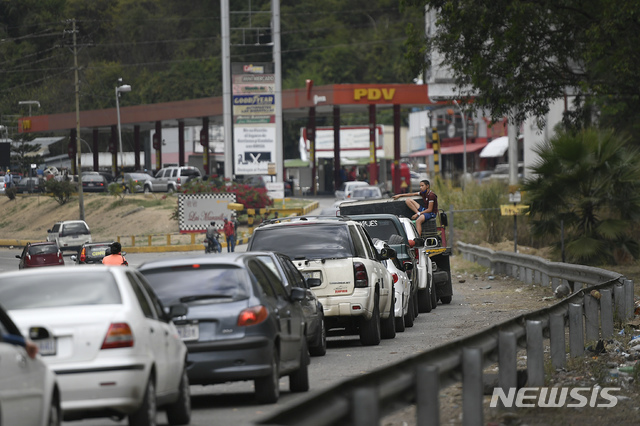 [카라카스=AP/뉴시스]19일(현지시간) 베네수엘라 수도 카라카스의 카리쿠아오 인근 한 주유소에 연료를 넣으려는 차량이 길게 줄 서 있다. 원유 매장 세계 1위의 베네수엘라는 경제 위기로 수백만 명이 나라를 떠나고 남은 대다수 사람은 휘발유를 포함해 기초 생필품마저 부족한 채 사는 것으로 나타났다. 2021.01.20.