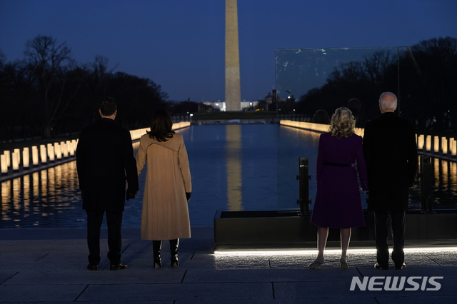 [워싱턴=AP/뉴시스]조 바이든(오른쪽) 대통령 당선인과 부인 질 바이든 여사가 취임식을 하루 앞둔 19일(현지시간) 워싱턴DC 링컨기념관에서 카멀라 해리스(왼쪽 세 번째) 부통령 당선인과 남편 더그 엠호프와 함께 코로나19 희생자들을 추모하고 있다. 2021.01.20.