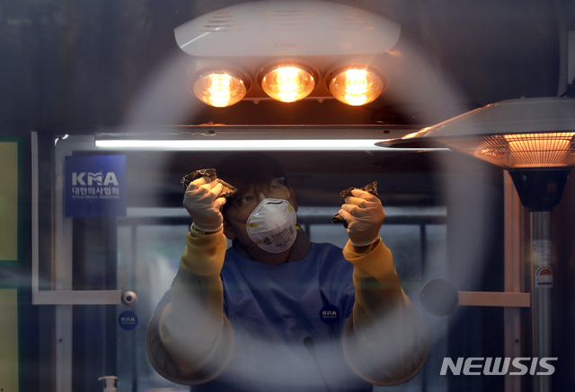 [서울=뉴시스]최진석 기자 = 국내 첫 신종 코로나바이러스 감염증(코로나19) 확진자 발생 1년이된 20일 중구 서울광장 임시선별검사소에서 의료진이 언 손을 온열기구에 녹이고 있다. 2021.01.20. myjs@newsis.com