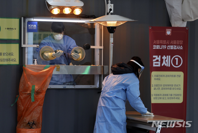 [서울=뉴시스]최진석 기자 = 국내 첫 신종 코로나바이러스 감염증(코로나19) 확진자 발생 1년이된 20일 중구 서울광장 임시선별검사소에서 관계자가 테이블을 소독하고 있다. 2021.01.20. myjs@newsis.com