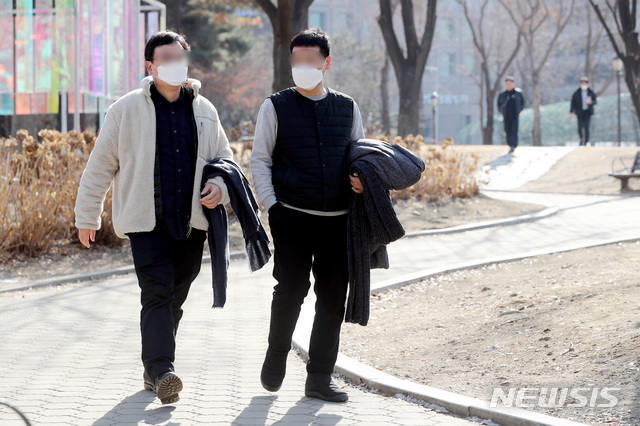 [서울=뉴시스]김병문 기자 = 20일 오후 점심시간 서울 영등포구 여의도공원에서 시민이 겉옷을 벗어 팔에 걸치고 있다. 2021.01.20. dadazon@newsis.com