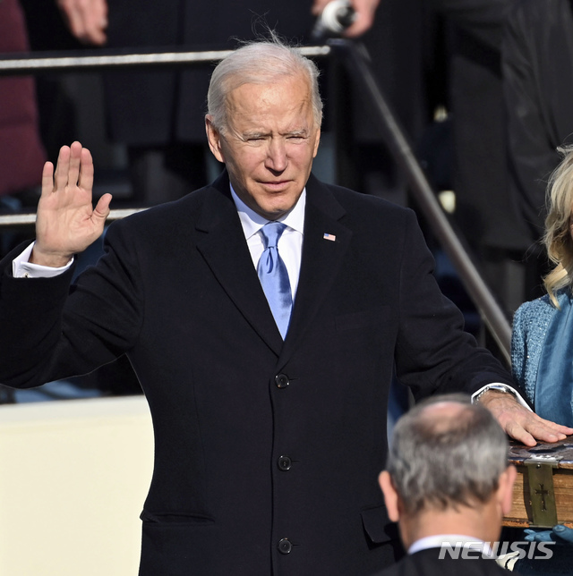  [워싱턴=AP/뉴시스]조 바이든 미국 대통령 당선인이 20일(현지시간) 미 의회 의사당에서 성경에 손을 얹고 존 로버츠 대법원장 앞에서 제46대 미국 대통령 취임 선서를 하고 있다. 2021.01.21.  