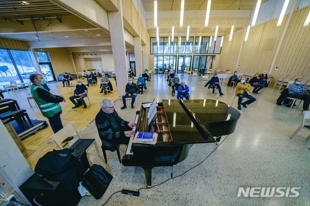 [AP/뉴시스] 1월21일 노르웨이 오슬로 인근 니테달에서 한 피아니스트가 코로나19 백신 접종을 기다리는 사람들을 우해 피아노를 연주하고 있다