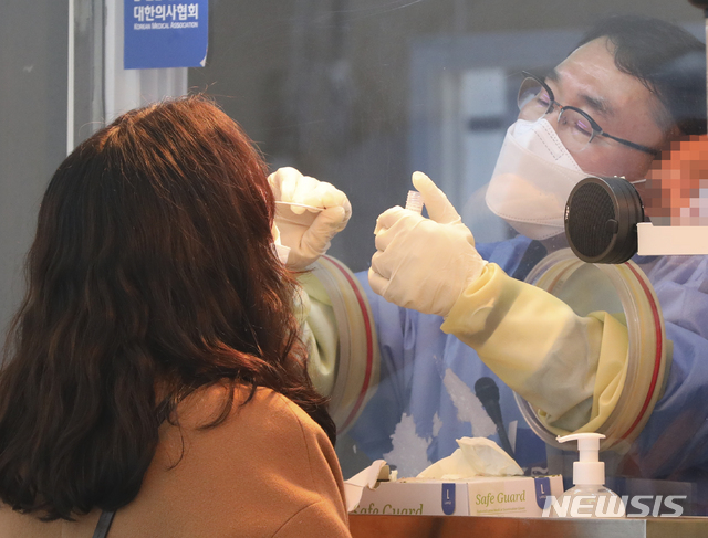 [서울=뉴시스]최진석 기자 = 신종 코로나바이러스 감염증(코로나19) 확진자가 3차 유행 이후 두달여 만에 최소인 346명으로 집계된 22일 오전 중구 서울광장에 마련된 중구임시선별검사소에서 한 사람이 검체 채취 검사를 받고 있다. 2021.01.22. myjs@newsis.com