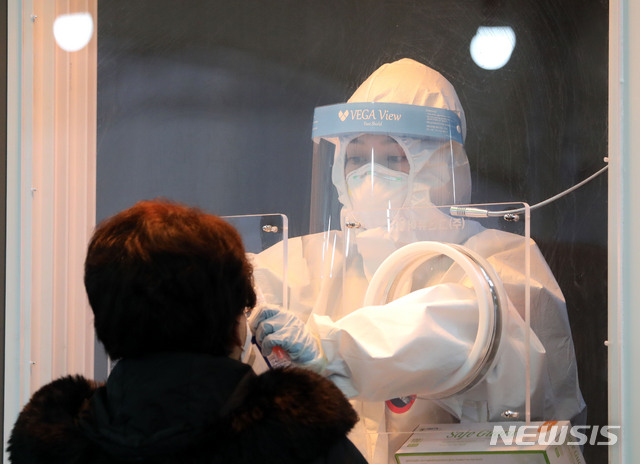 [서울=뉴시스]고범준 기자 = 22일 서울 서울역광장에 마련된 신종 코로나바이러스 감염증(코로나19) 임시 선별검사소에서 의료진이 검체 채취를 하고 있다. 2021.01.22. bjko@newsis.com