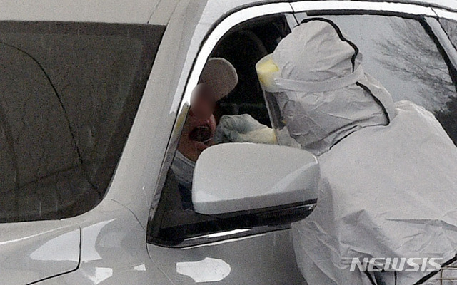 [대구=뉴시스] 이무열 기자 = 대구지역 신종 코로나바이러스 감염증(코로나19) 확진자가 12명으로 집계된 24일 대구 수성구 대구스타디움 제3주차장에 마련된 드라이브스루 코로나19 임시선별검사소에서 의료진이 검체 채취를 하고 있다. 2021.01.24. lmy@newsis.com