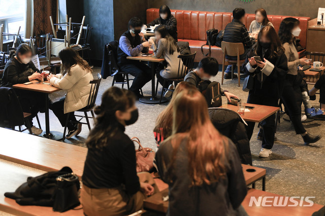 [서울=뉴시스]박민석 기자 = 다중이용시설에 대한 집합금지·운영제한이 완화된 이후 첫 주말인 24일 서울 시내의 한 프랜차이즈형 카페에서 시민들이 커피를 마시고 있다. 2021.01.24. mspark@newsis.com