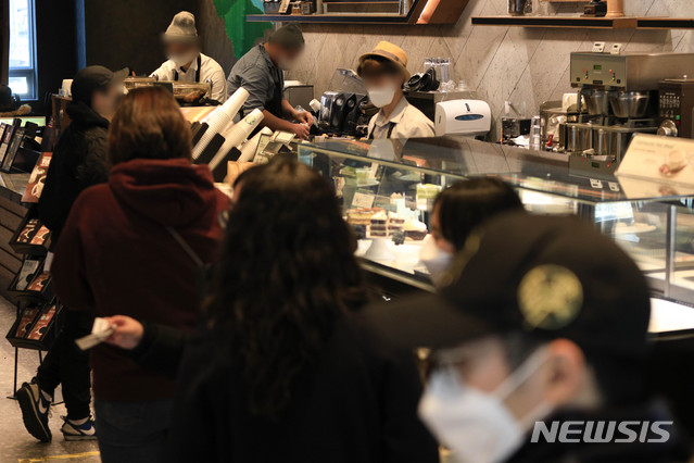 [서울=뉴시스]박민석 기자 = 다중이용시설에 대한 집합금지·운영제한이 완화된 이후 첫 주말인 24일 서울 시내의 한 프랜차이즈형 카페에서 시민들이 주문을 기다리고 있다. 2021.01.24. mspark@newsis.com