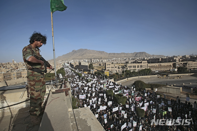 [사나=AP/뉴시스]25일(현지시간) 예멘 수도 사나에서 반미 시위가 열려 한 병사가 후티 반군 지지자들의 시위 모습을 바라보고 있다. 이들은 앞서 도널드 트럼프 행정부가 시아파 후티 반군을 테러조직으로 지정한 것에 반발하며 시위를 벌였다. 2021.01.26.