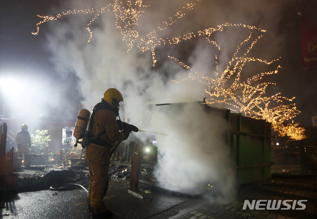 [로테르담=AP/뉴시스]25일(현지시간) 네덜란드 로테르담에서 코로나19 통행 금지에 반대하는 시위대가 컨테이너에 불을 질러 소방관들이 이를 끄고 있다. 네덜란드는 코로나19 확산 예방을 위해 밤 9시부터 다음 날 새벽 4시 30분까지 전국적인 야간 통행 금지를 시행하는 등 강도 높은 규제를 취하고 있으며 이에 대한 거센 반발도 이어지고 있다. 2021.01.26.