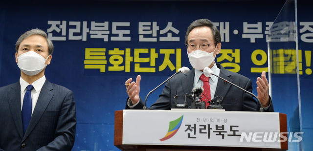 [전주=뉴시스] 김얼 기자 = 송하진(오른쪽) 전북도지사가 26일 전북 전주시 전북도청 기자회견장에서 전라북도 탄소 소재·부품·장비 특화단지 선정 의결 관련 브리핑을 열고 질의에 답변하고 있다. 2021.01.26.pmkeul@newsis.com