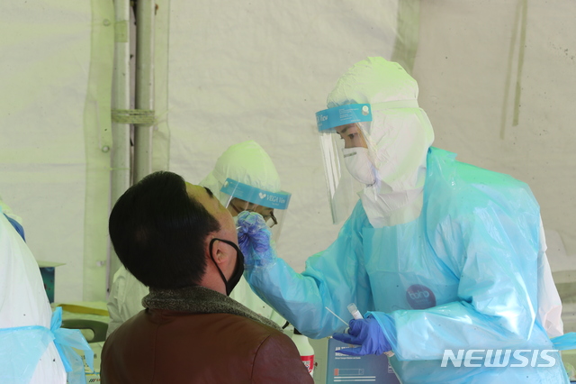 [포항=뉴시스] 강진구 기자 = 경북 포항시가 전 시민 가구당 1명 신종 코로나바이러스 감염증 진단검사 행정명령을 내린 둘째 날인 27일 오후 시청앞 임시선별진료소에서 한 시민이 진단검사를 받고 있다.2021.01.27.dr.kang@newsis.com