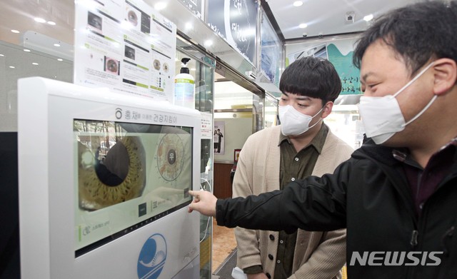 [서울=뉴시스]27일 서울 동작구청에서 구민들이 얼굴 홍채를 이용한 헬스 케어 기기를 이용하고 있다. 동작구는 스마트시티 통합플랫폼 서비스 인환으로 전국 자치구 최초로 민원실 앞에 헬스 케어 기기를 설치하고 구청을 방문한 구민들의 개인 건강을 체크할 수 있도록 서비스를 제공하고 있다. (사진=동작구 제공) 2021.01.27. photo@newsis.com